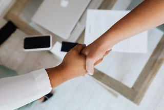 Picture of 2 people shaking hands.