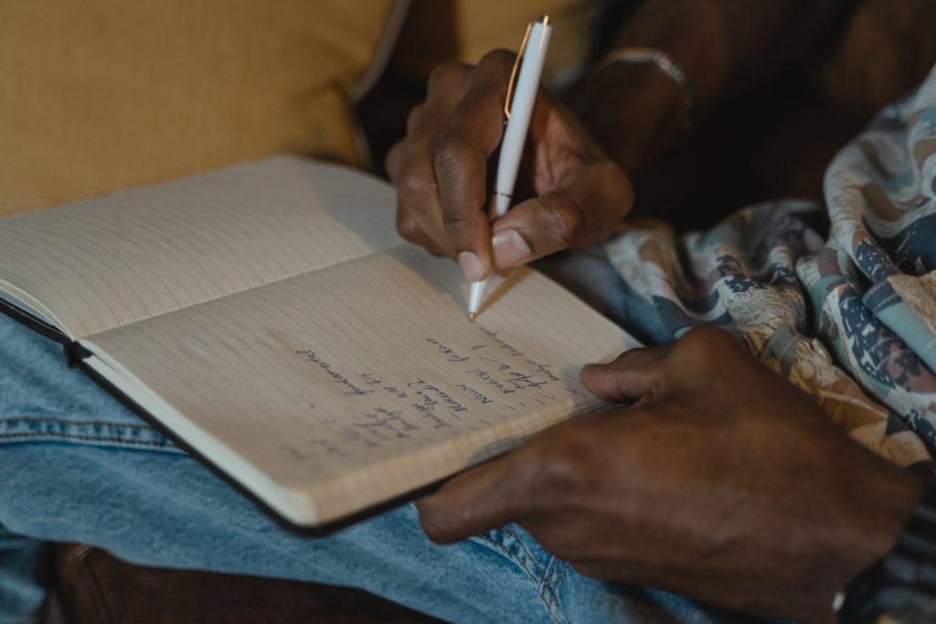 Woman writing in norepad with a pen