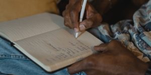 Woman writing in norepad with a pen